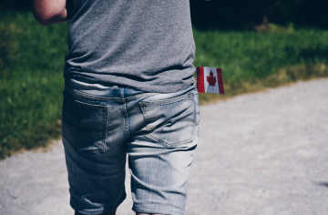 Personne qui marche avec un drapeau du Canada dans la poche du pantalon